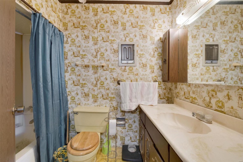 Full bathroom featuring shower / tub combo, vanity, and toilet