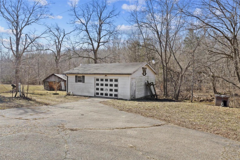View of property exterior featuring a garage and an outbuilding