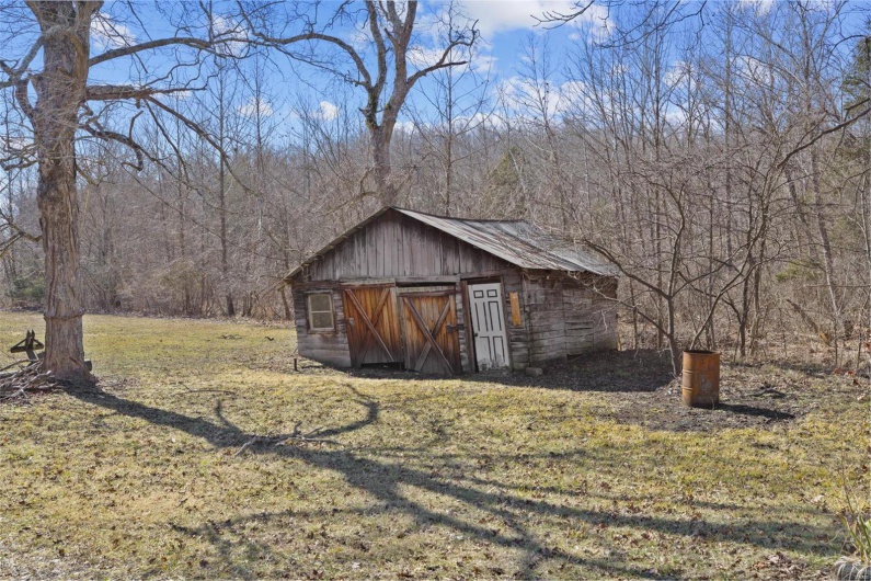 View of outdoor structure featuring a yard