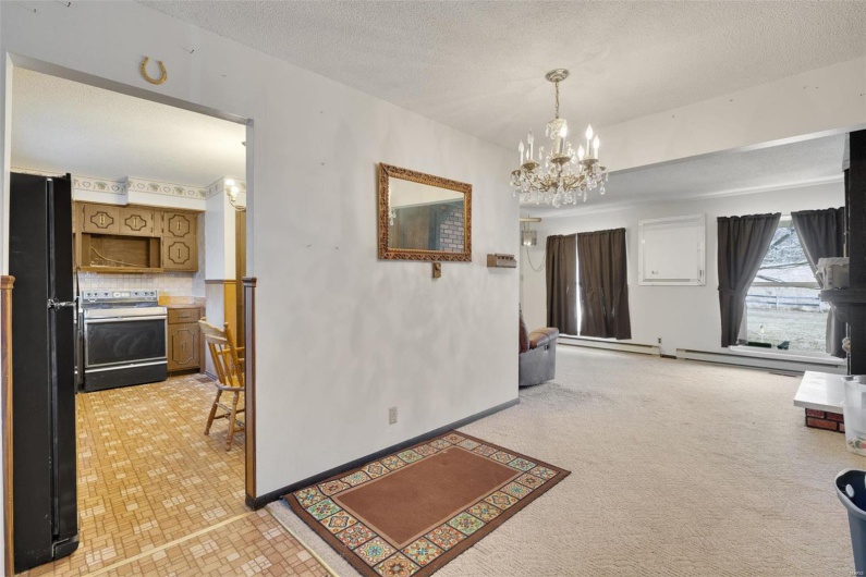 Hall with a chandelier, a textured ceiling, and baseboard heating