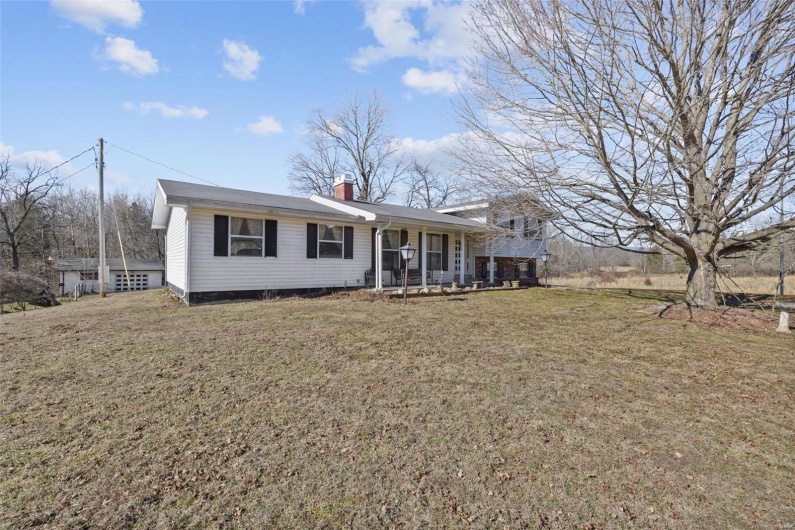 View of front of home with a porch and a front lawn