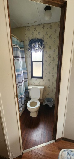 Bathroom with hardwood / wood-style floors and toilet