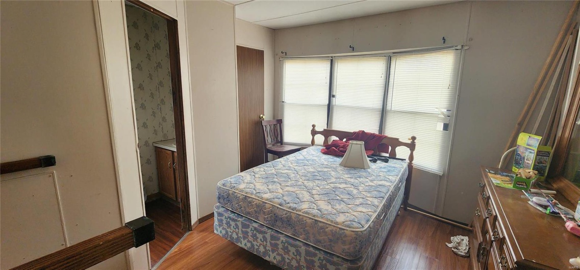 Bedroom with dark hardwood / wood-style flooring