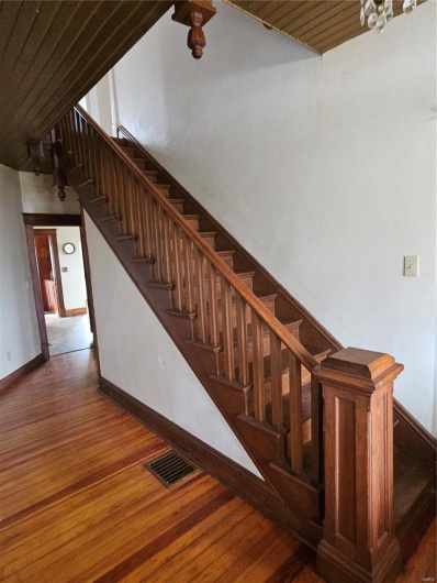 Stairway featuring wood-type flooring and a high ceiling
