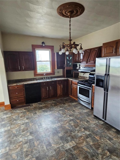 Kitchen with sink, fridge, dishwasher, stove, and exhaust hood