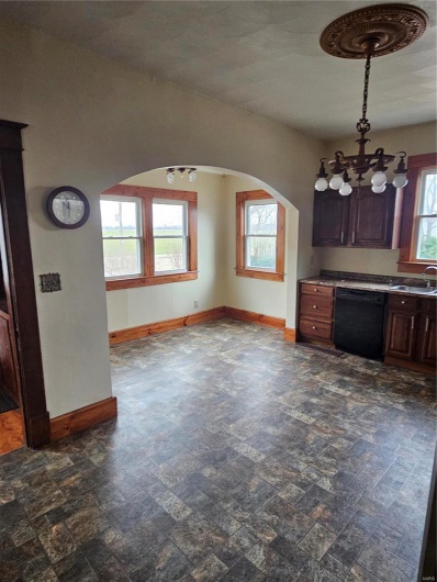 Kitchen featuring dark brown cabinetry, dishwashing machine, sink, and plenty of natural light
