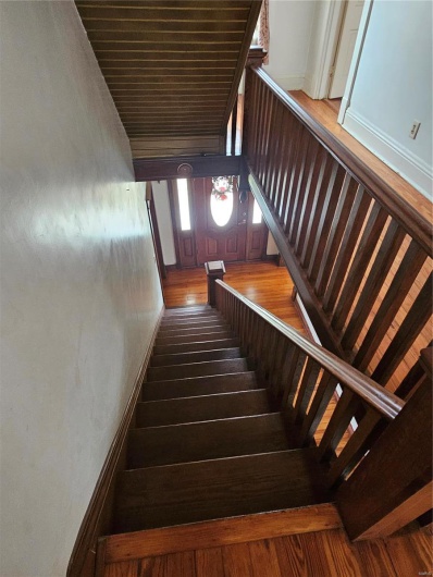 Stairs featuring hardwood / wood-style flooring