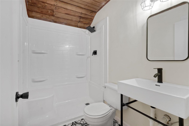 Third floor studio. Bathroom with lofted ceiling, sink, walk in shower, wood ceiling, and toilet