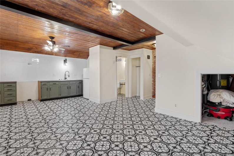 Third floor studio. Living room with ceiling fan, beam ceiling, sink, and wooden ceiling
