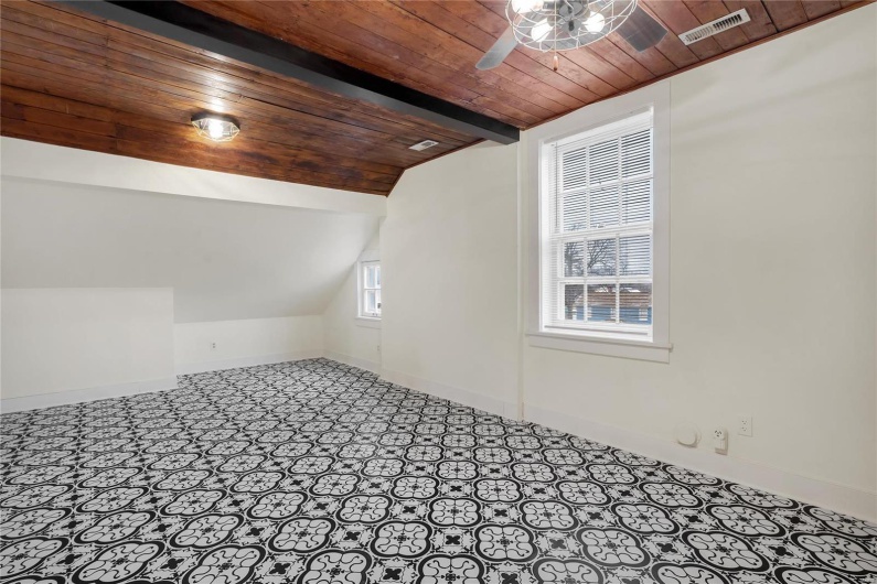 Third floor studio. Additional living space with lofted ceiling with beams, wooden ceiling, and ceiling fan