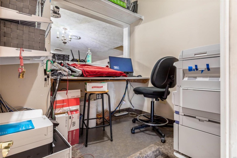 Office space with concrete floors and a textured ceiling