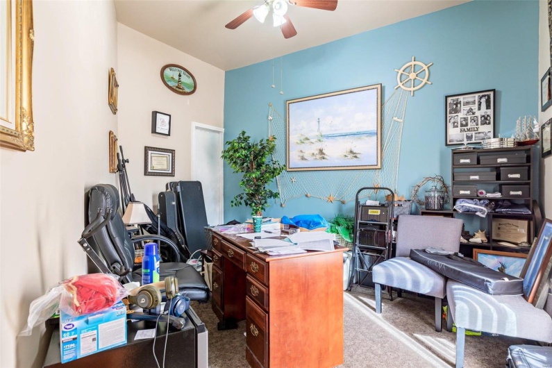 Carpeted office space featuring ceiling fan