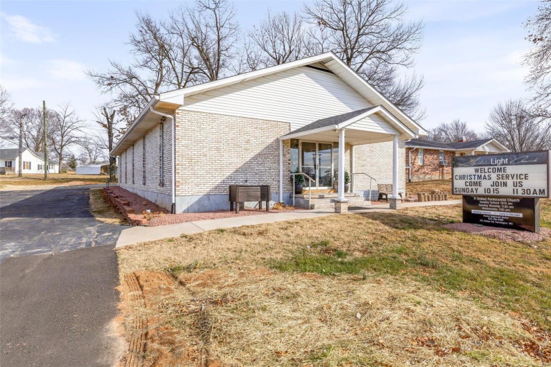 View of home's exterior featuring a porch and a yard