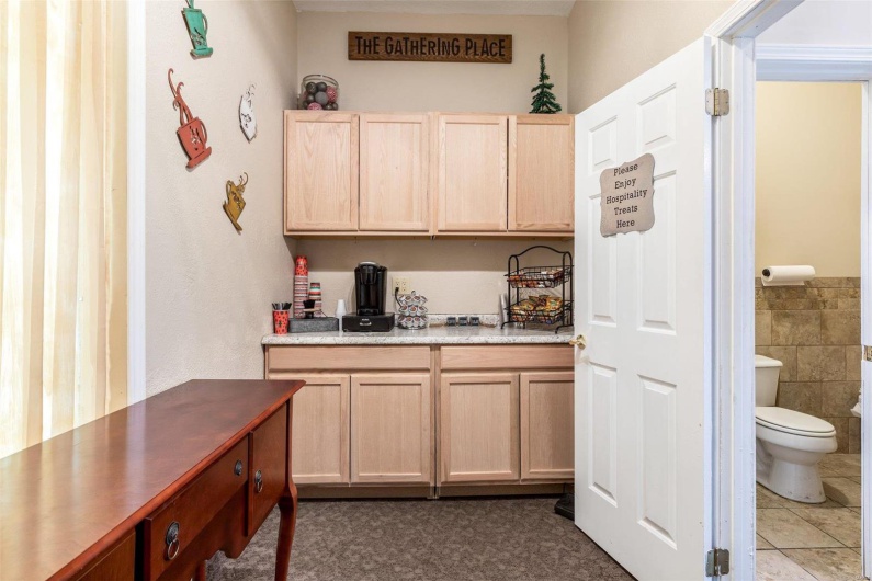 Kitchen with tile walls, tile patterned floors, and light brown cabinetry