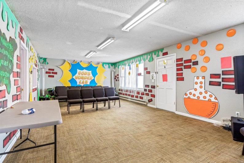 Rec room with a baseboard radiator, carpet floors, and a textured ceiling