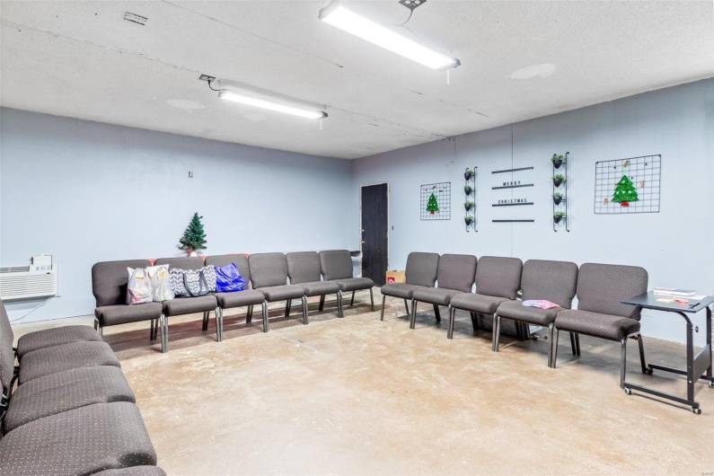 Living room with a textured ceiling, concrete floors, and a wall mounted AC