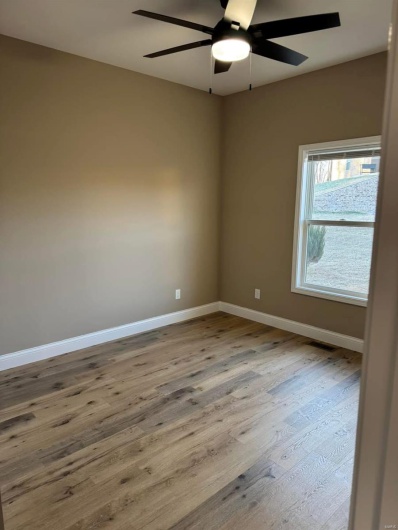 Unfurnished room featuring hardwood / wood-style floors and ceiling fan