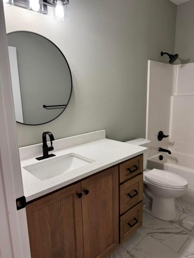Full bathroom with vanity,  shower combination, and toilet