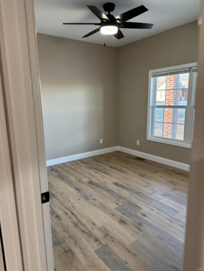 Spare room with hardwood / wood-style flooring and ceiling fan