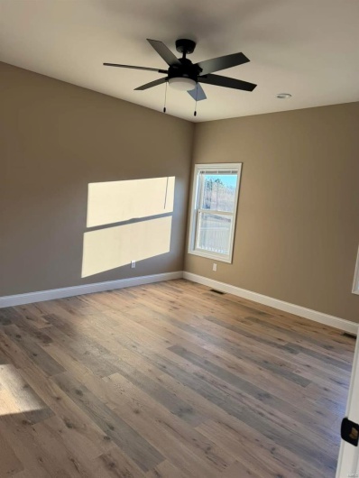 Unfurnished room featuring hardwood / wood-style flooring and ceiling fan