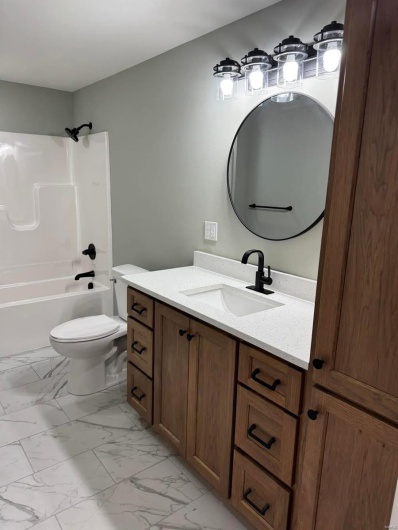 Full bathroom with vanity, washtub / shower combination, and toilet