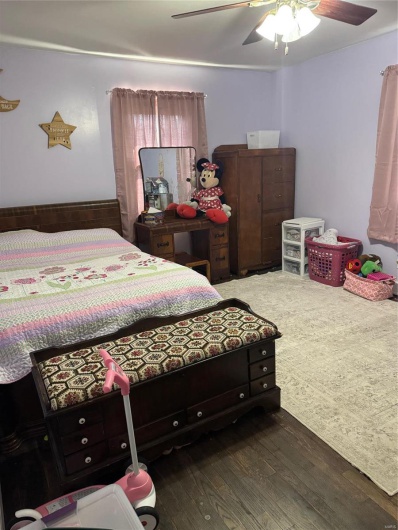 Bedroom with ceiling fan and dark hardwood / wood-style floors