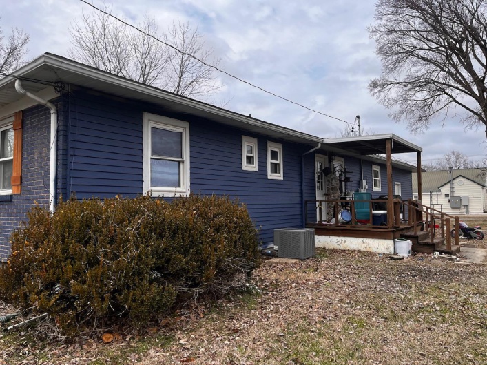 View of side of property with central AC unit and covered porch