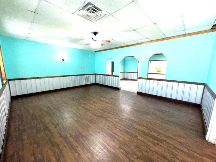 Spare room with ceiling fan, dark hardwood / wood-style flooring, and a drop ceiling