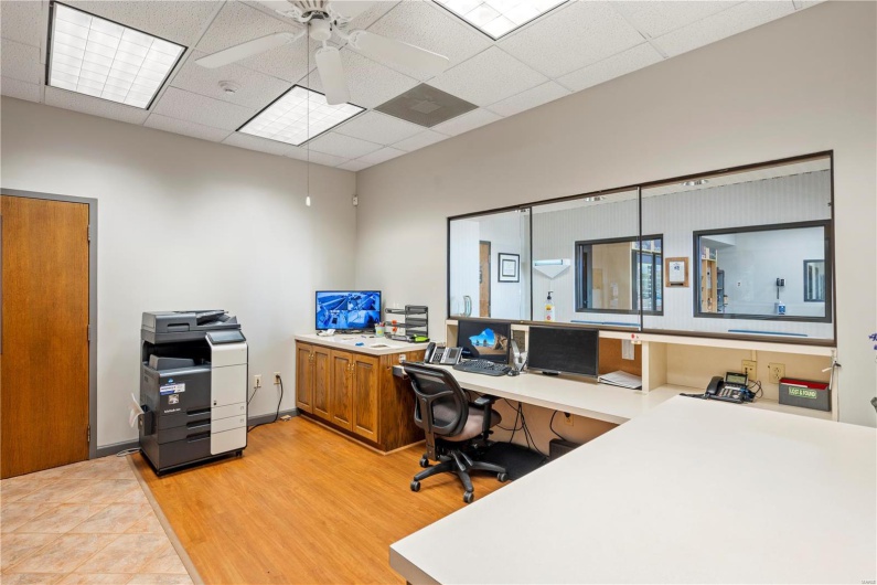 Office area with ceiling fan, light hardwood / wood-style floors, and a paneled ceiling