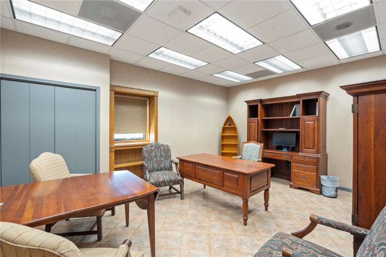 Office with light tile patterned flooring and a drop ceiling