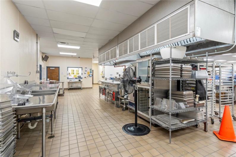 Miscellaneous room featuring tile patterned flooring, a paneled ceiling, and a workshop area