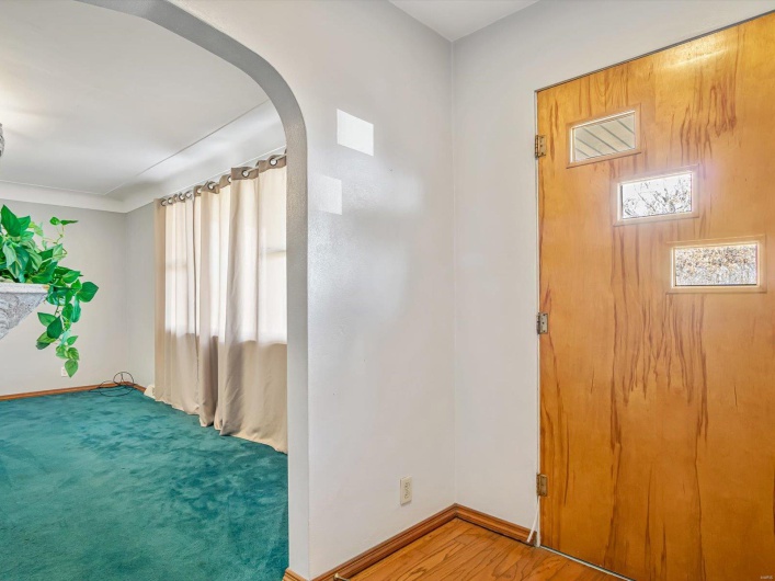 Entryway with baseboards, arched walkways, and wood finished floors