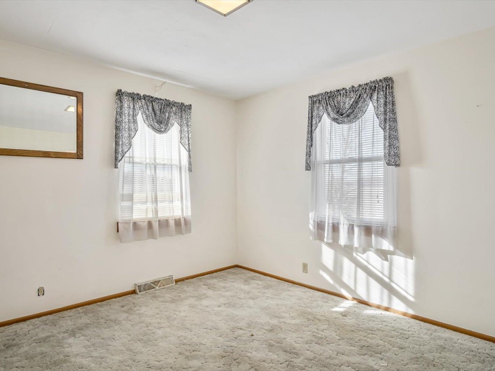 Spare room with carpet, visible vents, and baseboards