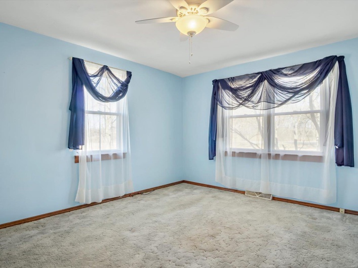 Spare room with carpet floors, ceiling fan, visible vents, and baseboards