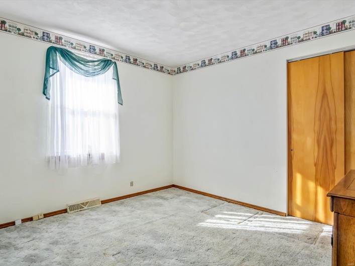 Carpeted spare room featuring baseboards and visible vents