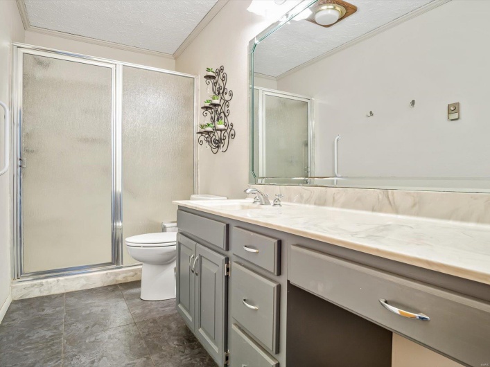 Full bath featuring a shower stall, a textured ceiling, toilet, and vanity