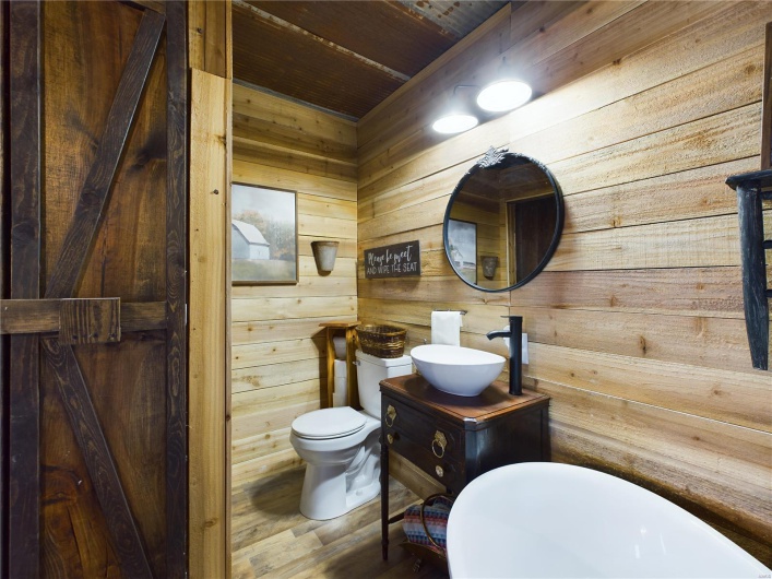 Bathroom with hardwood / wood-style floors, vanity, wooden ceiling, toilet, and wooden walls