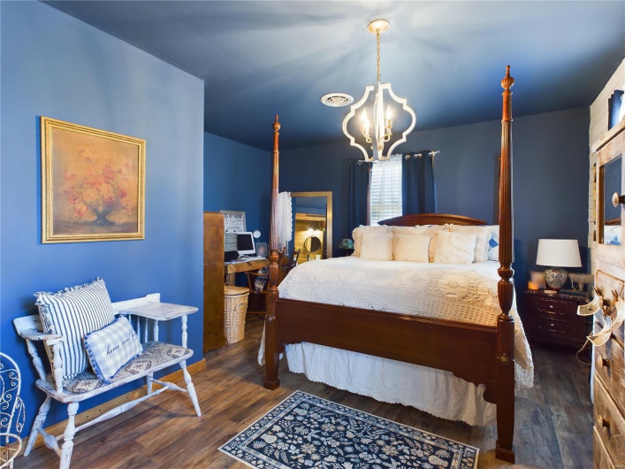 Bedroom featuring an inviting chandelier and dark wood-type flooring