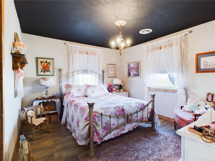 Bedroom with an inviting chandelier, a textured ceiling, and dark hardwood / wood-style floors