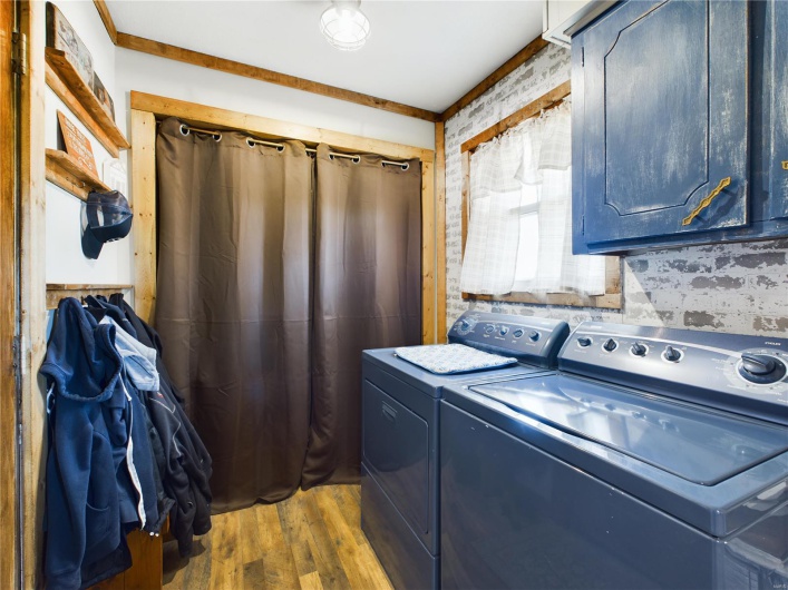 Washroom with cabinets, washer and dryer, and dark wood-type flooring