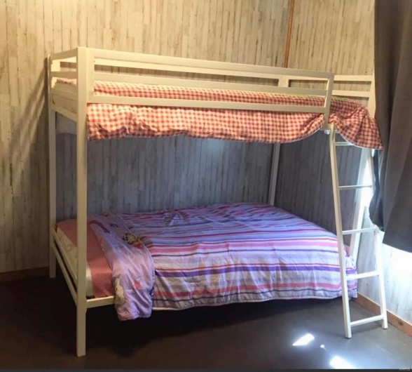 Bedroom with finished concrete flooring and wooden walls