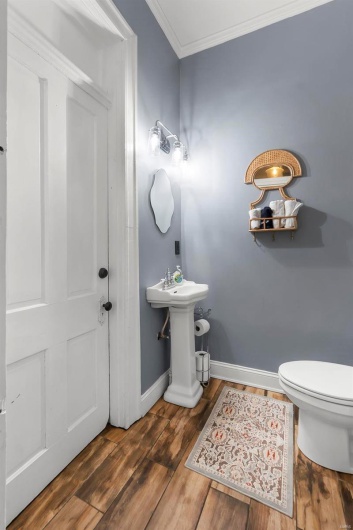 Bathroom with crown molding, wood look tile flooring, and toilet