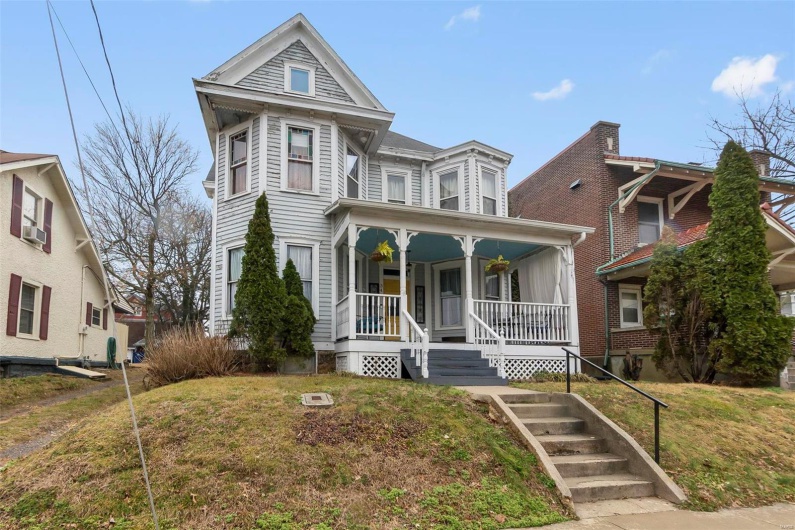 View of front of house with a porch, and a front yard