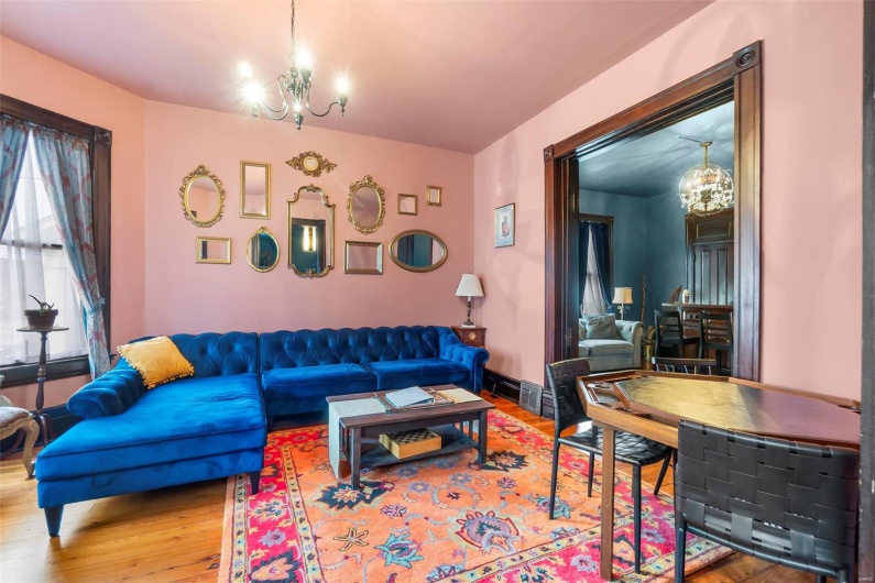 Living room with hardwood  flooring and an inviting chandelier