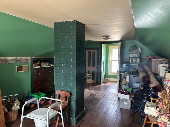 Rec room with vaulted ceiling, wood finished floors, and visible vents