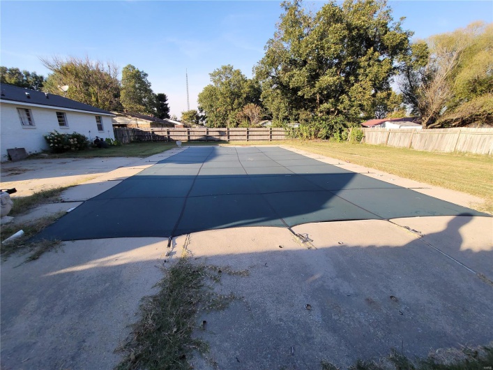 View of pool featuring a patio, a lawn, and a fenced backyard