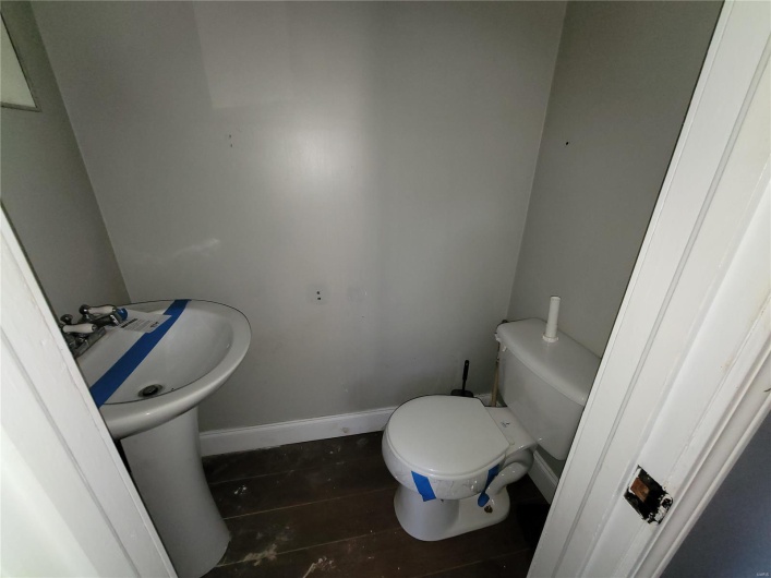 Half bathroom with toilet and baseboards