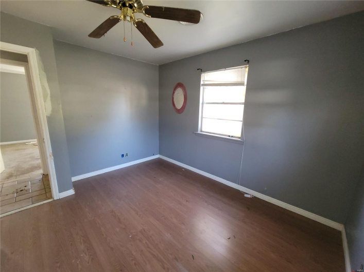Spare room with dark wood finished floors, baseboards, and ceiling fan