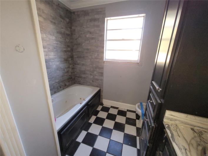 Full bath featuring a whirlpool tub, baseboards, and tile patterned floors