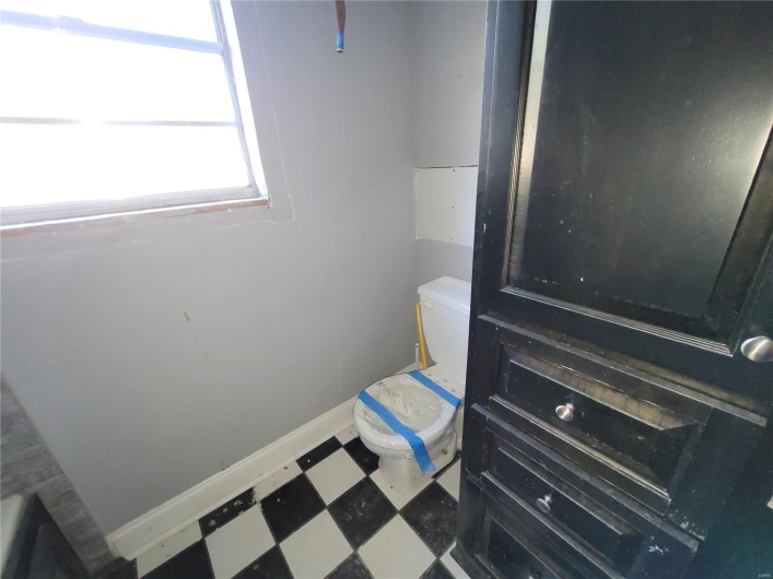 Bathroom featuring toilet, baseboards, and tile patterned floors